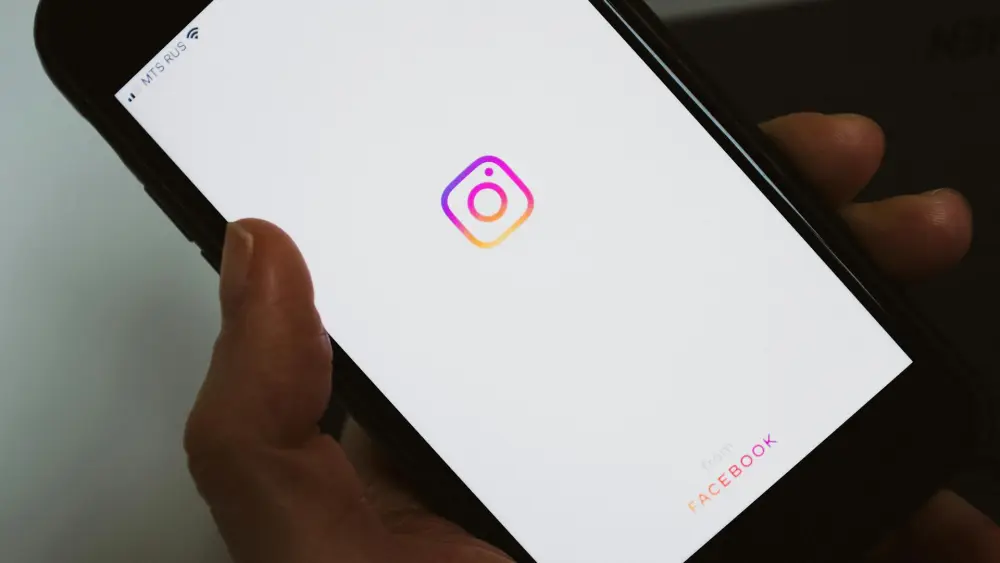 A person holding a cellphone with the Instagram logo on the screen. Credit: ready made/Pexels.