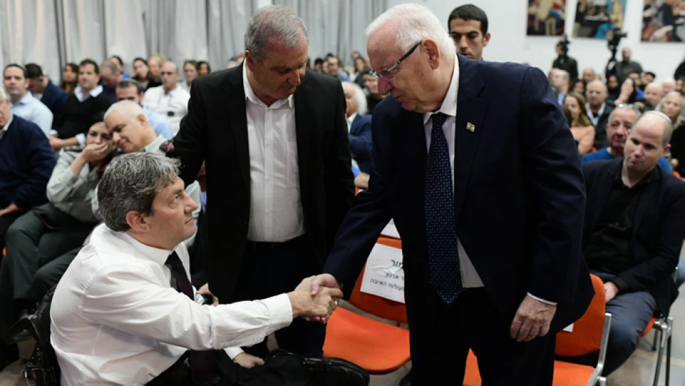 Israeli President Reuven Rivlin shakes hands with Idan Clayman, head of the IDF Organization for the Disabled, at an event in honor of Israeli soldiers disabled in the line of duty, at Beit Halochem in Tel Aviv on Dec. 15, 2019. Photo by Tomer Neuberg/Flash90.
