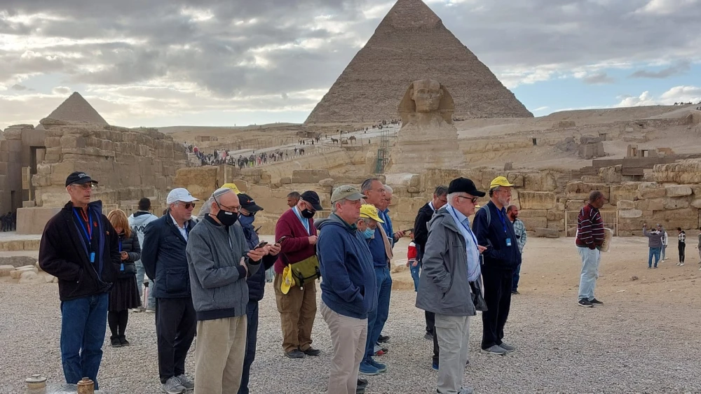 Participants on the trip hold Mincha, the afternoon prayer service, in front of the pyramids in Egypt. Credit: Courtesy.