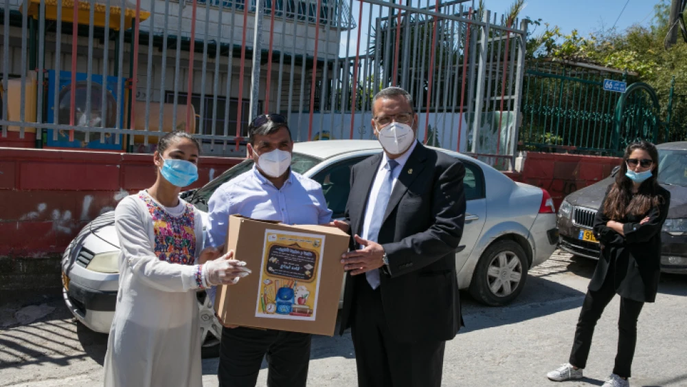 Israeli soldiers of the Home Front Command Unit and Jerusalem Mayor Moshe Lion give out food packages via a local NGO in the eastern Jerusalem neighborhood of Abu Tor on April 30, 2020. Photo by Olivier Fitoussi/Flash90.
