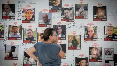 A woman looks at photographs of Israelis held by Hamas in Gaza, at "Hostage Square" outside the Tel Aviv Museum of Art, Oct. 30, 2023. Photo by Miriam Alster/Flash90.