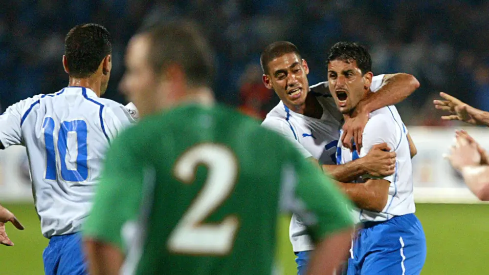 Israel's Abbas Suan (right) is congratulated by teammate Yaniv Katan after he scored against Ireland while Stephan Carr looks at them during a 2006 World Cup qualifying soccer match at Ramat Gan Stadium near Tel Aviv on March 26, 2005. Photo by Pedro Ugarte/AFP via Getty Images.