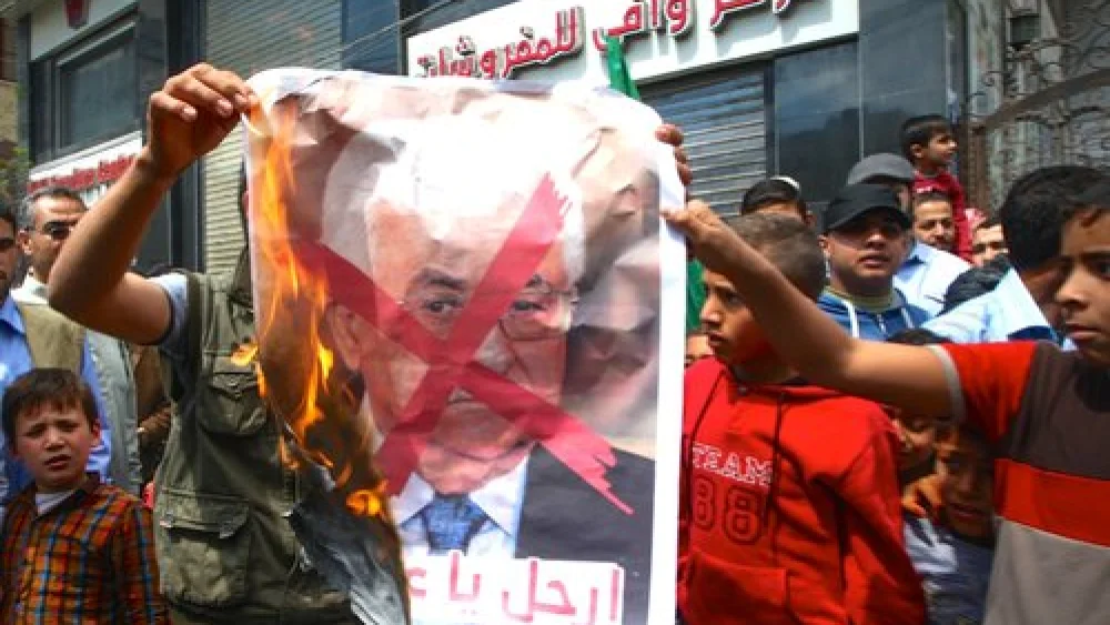 Palestinians burn a poster bearing a crossed-out image of Palestinian Authority (PA) President Mahmoud Abbas during a protest against both the Israeli government and the PA in the southern Gaza Strip, April 14, 2017. Credit: Abed Rahim Khatib/Flash90.