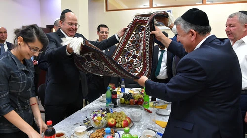Israeli Minister of Defense Moshe Ya'alon (pictured at left, in center, holding rug) meets with representatives from the Jewish community in Baku, Azerbaijan's capital, on September 10, 2014. Credit: Ariel Hermoni/Ministry of Defense/Flash90.