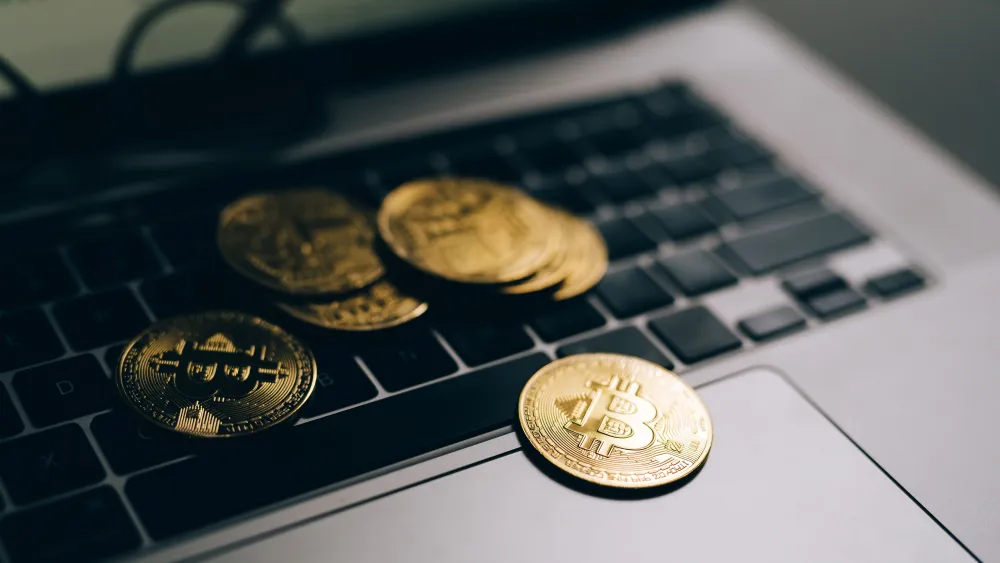 Close-up of golden bitcoins on a laptop keyboard. Credit: Olya Kobruseva/Pexels.