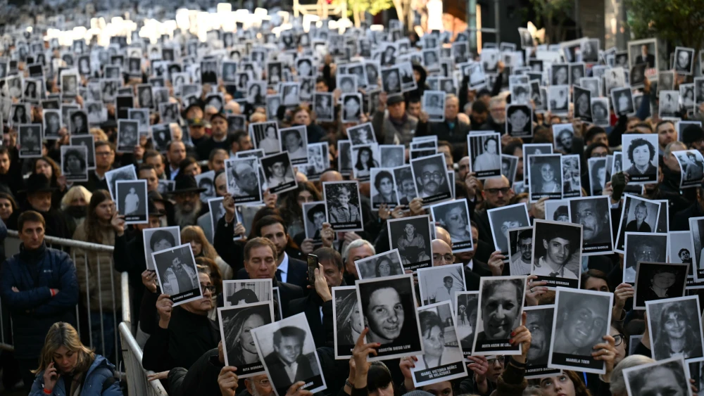 People hold pictures of victims during a ceremony to commemorate the 31st anniversary the Mutual Israelite Association of Argentina (AMIA) bombing attack which left 85 dead and more than 300 wounded, in Buenos Aires on July 18, 2025. Photo by Luis Robayo / AFP via Getty Images.