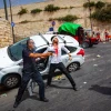 An Israeli policeman fends off an angry Arab mob swarming an Israeli motorist, pelting his car with stones and driving him off the road, outside Jerusalem's Old City, May 10, 2021. Photo by Olivier Fitoussi/Flash90.