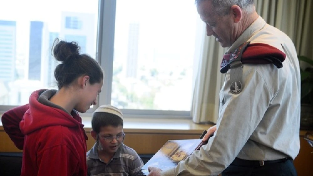 Former IDF Chief of Staff Lt. Benny Gantz meets with two surviving children of the Fogel family, whose parents and three siblings were murdered by Palestinians in the March 2011 Itamar massacre. Credit: Israel Defense Forces.