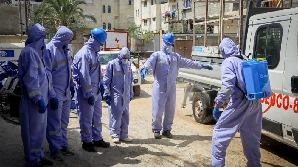 Palestinian Energy Company workers wear protective clothing and masks during their work following the outbreak of the coronavirus (COVID-19) in the Gaza Strip, April 6, 2020. Photo by Abed Rahim Khatib/Flash90.
