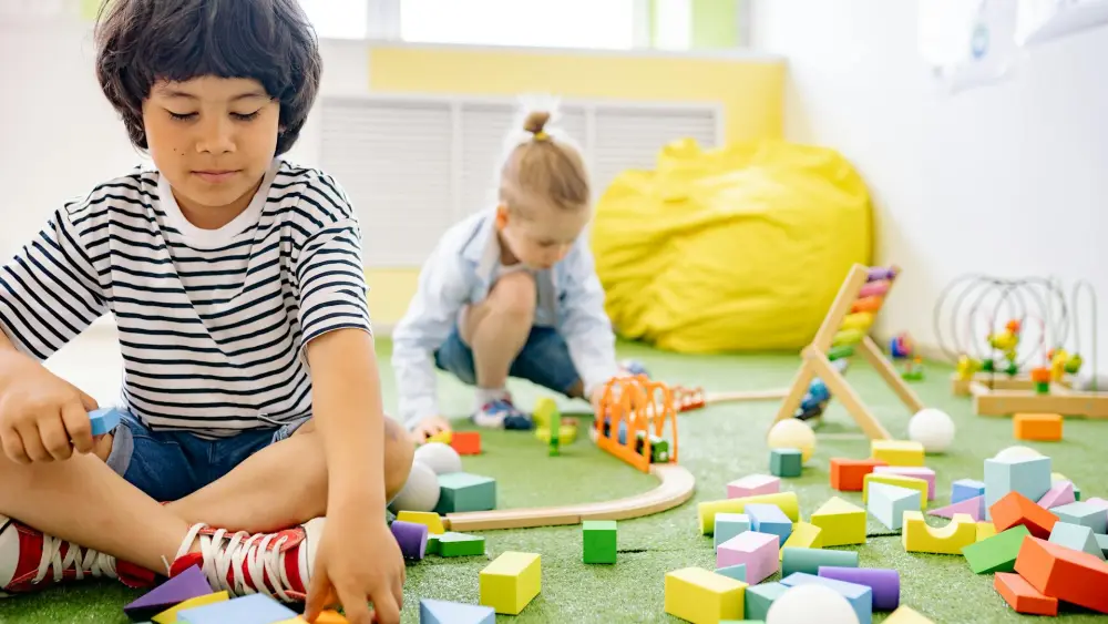 Two children playing with wooden toys in a preschool classroom. Credit: Yan Krukau/Pexels.