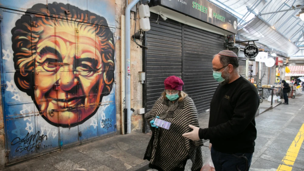 A couple walking in the Mahane Yehuda Market in Jerusalem. March 20, 2020. Photo by Olivier Fitoussi/Flash90.