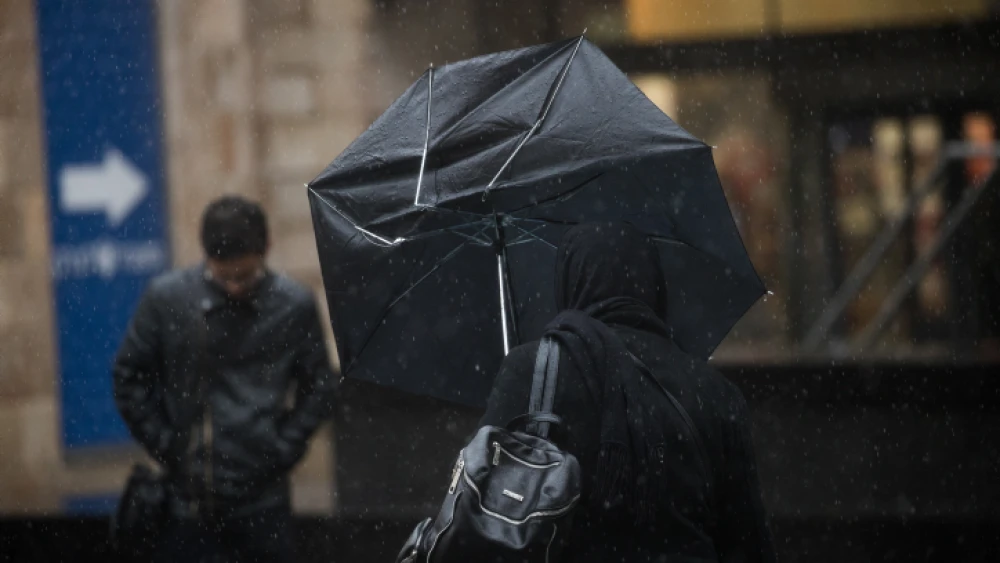 People walk in central Jerusalem on an especially wet day on Dec. 27, 2018. Photo by Yonatan Sindel/Flash90.