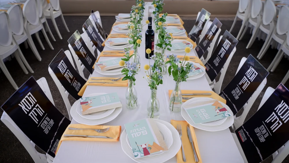 Members of Kibbutz Be'eri set a table for the Passover seder at Hostages Square in Tel Aviv. April 22, 2024. Photo by Avshalom Sassoni/Flash90.