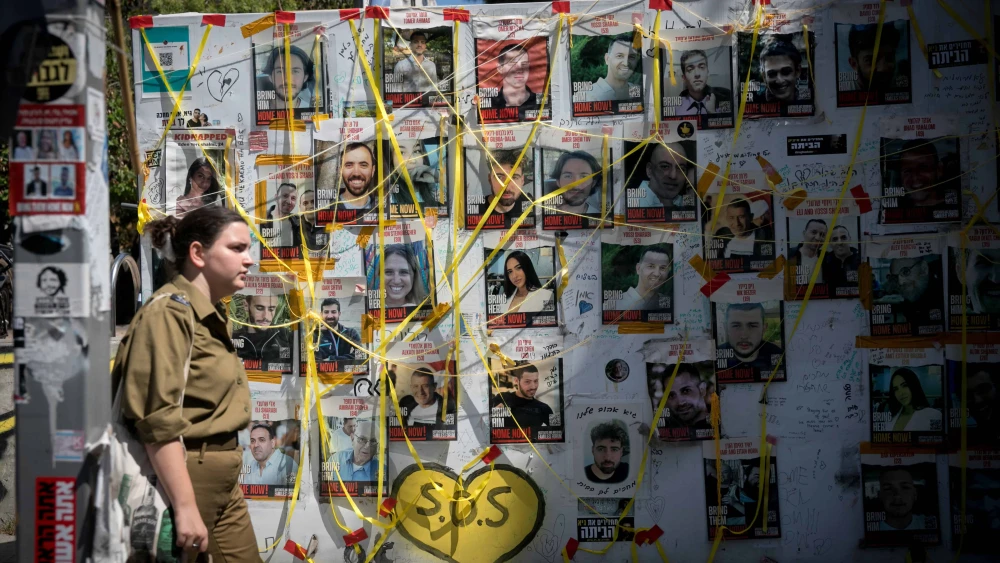 A woman walks past pictures at "Hostage Square" in Tel Aviv of Israelis held hostage by Hamas terrorists in Gaza, June 16, 2024. Photo by Miriam Alster/Flash90.