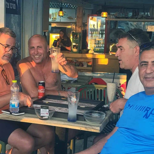 Ron Hazan raises a glass with friends at Moshav Shavei Tzion in the Western Galilee on June 24, 2025. Photo by Canaan Lidor.