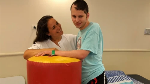 Dr. Adi Gidali, a New York-trained physical therapy supervisor at the Outpatient Brain Injury Unit at Sheba Medical Center, with 24-year-old recovering patient Netanel Felber. Credit: Sheba Medical Center.