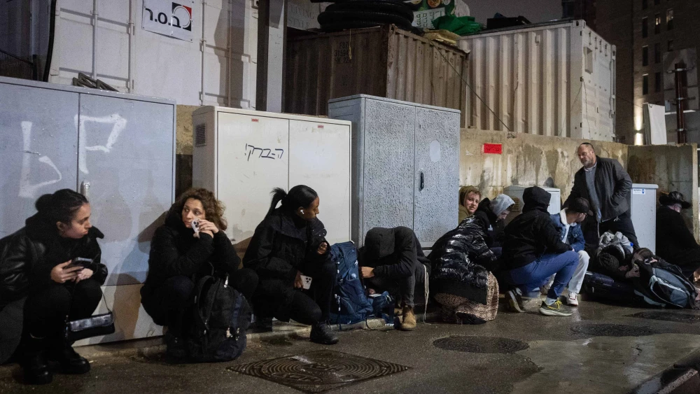 People take cover as siren warns of incoming missile fired from Yemen in Jerusalem, March 20, 2025. Photo by Chaim Goldberg/Flash90.