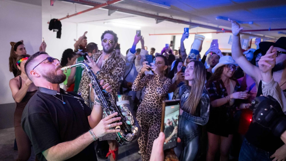 People dance during the Jewish holiday of Purim at an underground parking lot amid missile attacks emanating from the Islamic Republic, March 2, 2026. Photo by Chaim Goldberg/Flash90.