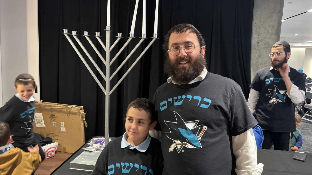 Rabbi Shaya Bernstein, co-director of the Chabad of Downtown San Jose, in front of a menorah at SAP Center in San Jose, Calif. Credit: Aaron Bandler.