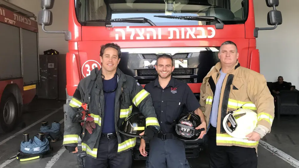 Emergency Volunteer Project Deployment director Eitan Charnoff (center) and volunteer U.S. firefighters Spencer MacWilliams (left) and Jake Papageorgio at a fire station in Jerusalem. Credit: Courtesy.
