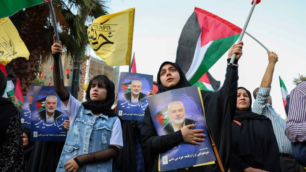 Iranians wave Palestinian flags and hold portraits of slain Hamas leader Ismail Haniyeh during a protest denouncing his killing, at Palestine square in the capital Tehran on July 31, 2024. Photo by/AFP via Getty Images.