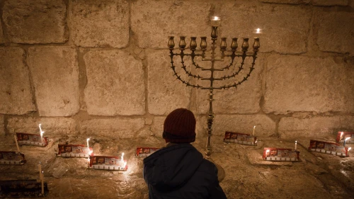 Candles on the first night of the Jewish holiday of Hanukkah, in the Jerusalem neighborhood of Mea Shearim. Hanukkah, also known as the “Festival of Lights,” is an eight-day Jewish holiday commemorating the rededication of the Holy Temple. The festival is observed by the kindling of the lights of a “hanukkiyah,” a nine-branched candelabrum with one additional light being lit on each night of the holiday. Dec. 24, 2016. Photo by Sebi Berens/Flash90.