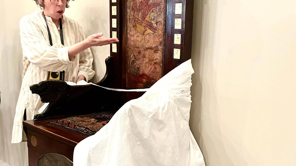 Conservation lab curator Sharon Tagar uncovers Elijah's Chair being restored at the lab. Photo by Judy Lash Balint.