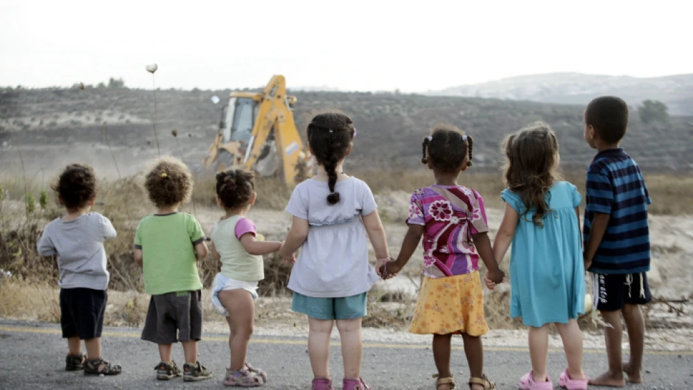 Israeli children watch construction work in Kedumim, Samaria. Photo by Uri Lenz/Flash90.