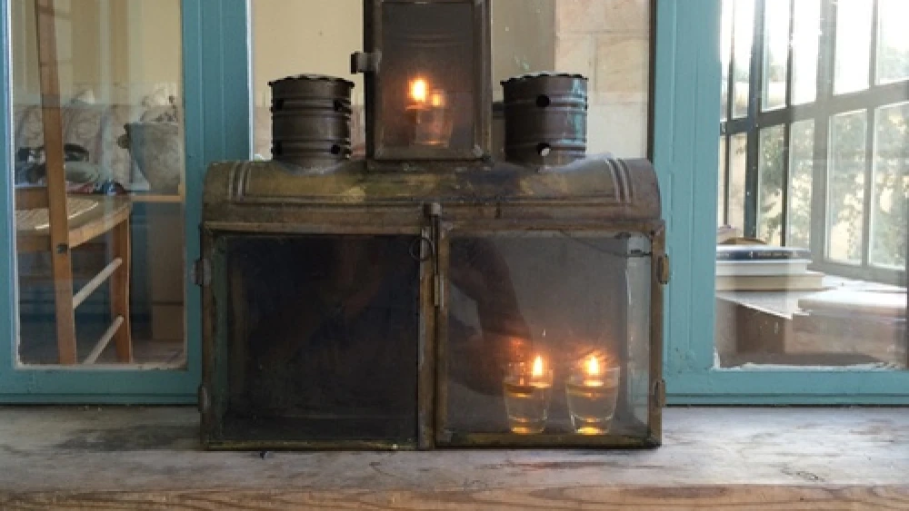Yael Scalia Hershberg's Hanukkah menorah, in which nine shot glasses filled with olive oil (and each topped with a wick) are placed in a simple box fashioned of brass and tin. The box was purchased from a craftsman in the Jerusalem neighborhood of Mea Shearim. Credit: Yael Scalia Hershberg.