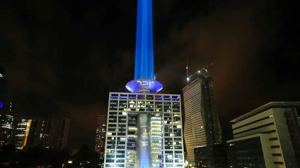 A massive memorial candle is projected atop the Israeli Defense Ministry building in Tel Aviv ahead of Yom Hazikaron, April 19, 2026. Credit: Defense Ministry's Spokesperson's Unit.