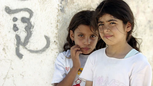 Posing next to graffiti are two young residents of Aqabat Jaber, a United Nations Relief and Works Agency for Palestine Refugees in the Near East (UNRWA) camp for Palestinian refugees located near Jericho. Credit: UN Photo/Stephenie Hollyman.