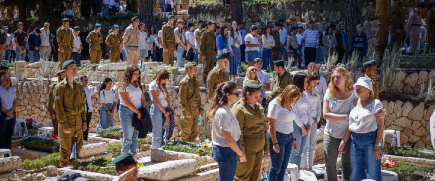 Israelis stand in silence next to the graves of soldiers in the Mount Herzl military cemetery in Jerusalem, as a two-minute siren sounds across the country on Memorial Day, April 25, 2023. Photo by Erik Marmor.