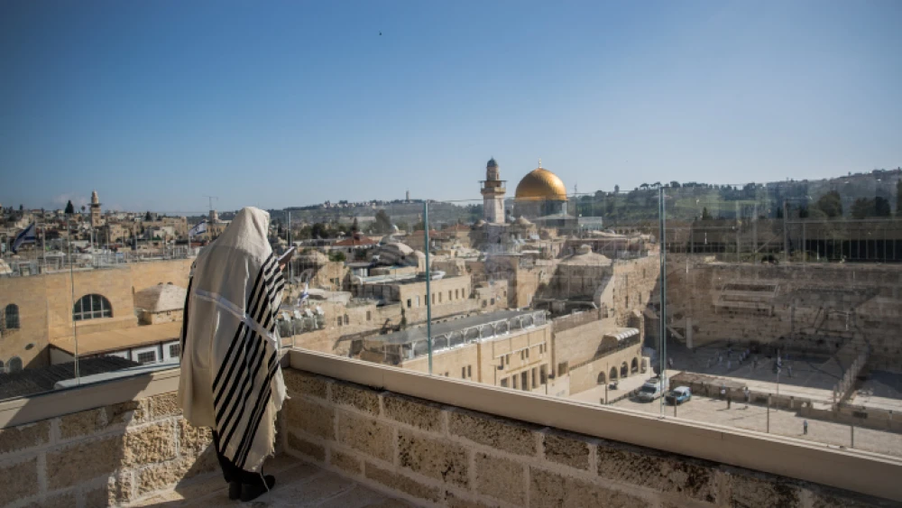 A man covers himself with a prayer shawl while praying near the Western Wall, Judaism's holiest prayer site, in Jerusalem's Old City, during the Passover priestly blessing service while the country grapples with the coronavirus pandemic, on April 12, 2020. Photo by Yonatan Sindel/Flash90.