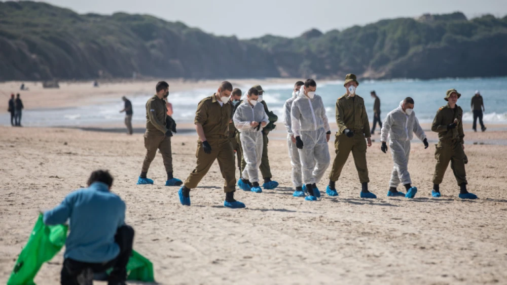 Israel Defense Forces soldiers clean tar off the Palmachim beach following an offshore oil spill that polluted much of the Israeli coastline, Feb. 22, 2021. Photo by Yonatan Sindel/Flash90.
