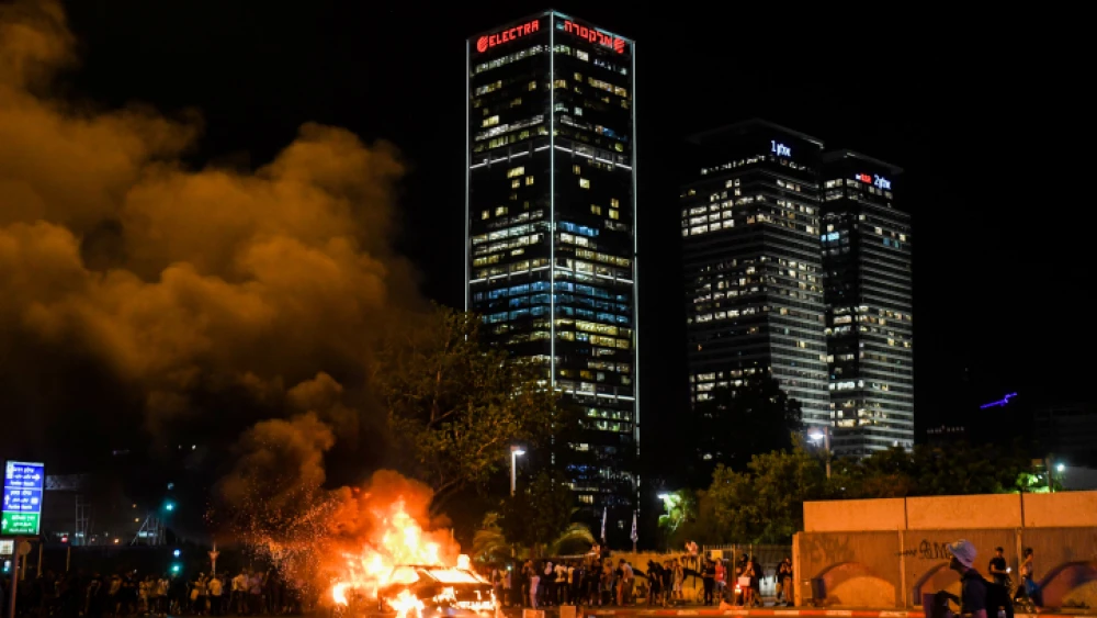 A car is lit on fire in Tel Aviv during a protest over the June 30 shooting death of 19-year-old Ethiopian Solomon Tekah in Kiryat Haim, July 2, 2019. Photo by Flash90.