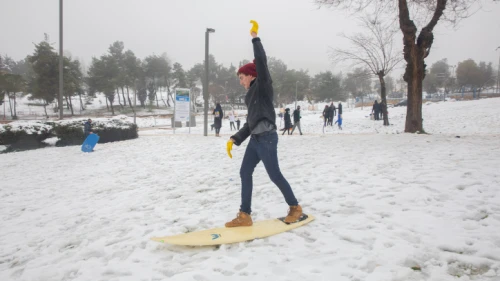 An Israeli teen uses a surfboard to play in the snow in Jerusalem on Feb. 18, 2021. Photo by Olivier Fitoussi/Flash 90.