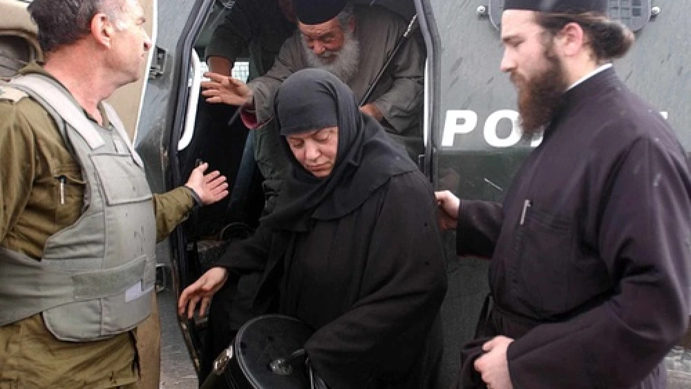 Click photo to download. Caption: An Israeli soldier helps to smuggle out a priest and a nun from the Church of the Nativity in Bethlehem on April 7, 2002. That year, a siege by Palestinian militants on the Church of the Nativity persisted from April 2 to May 10—just days after Easter on the Eastern Orthodox calendar. Credit: Flash90.