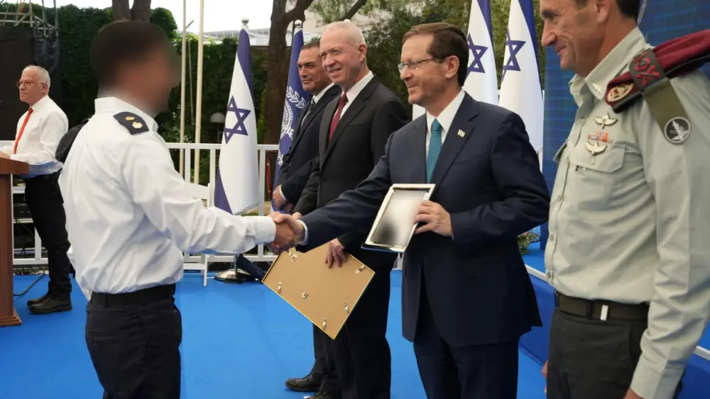President Isaac Herzog, with Defense Minister Yoav Gallant to his right and IDF Chief of Staff Lt. Gen. Herzi Halevi to his left, hands an award to one of the winners. Credit: Ministry of Defense Spokesperson’s Office.