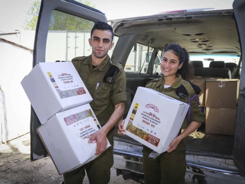 Representatives of IDF units hold food products donated by residents in the surrounding communities in Gush Etzion that will be giving away later to families of IDF soldiers, in Gush Etzion, in Judea and Samaria, on March 28, 2017, ahead of the Jewish holiday of Passover. Photo by Gershon Elinson/Flash90.