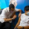 A young Israeli receives a booster shot of the Pfizer/BioNTech COVID-19 vaccine, Sept. 20, 2021. Photo by Olivier Fitoussi/Flash90.