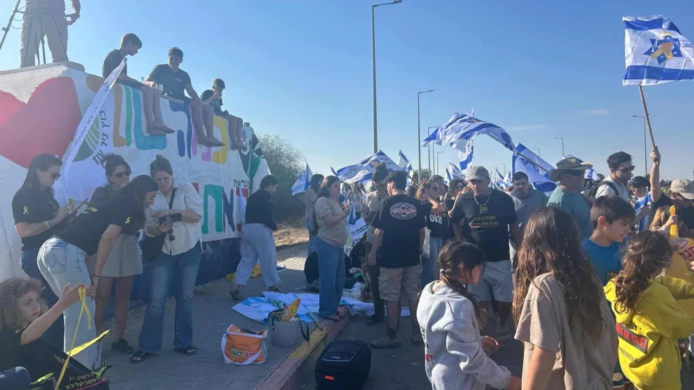 Israelis gather along Road 232 near the IDF’s Re’im base to welcome home the freed hostages, Oct. 13, 2025. Photo by Amelie Botbol.