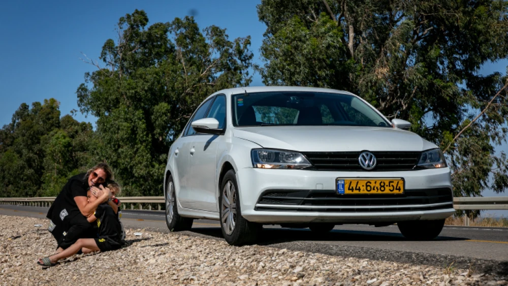 A woman and child take cover as a siren sounds, warning of incoming rockets from the Gaza Strip, on a road between Ashkelon and Sderot, May 19, 2021. Photo by Olivier Fitoussi/Flash90.