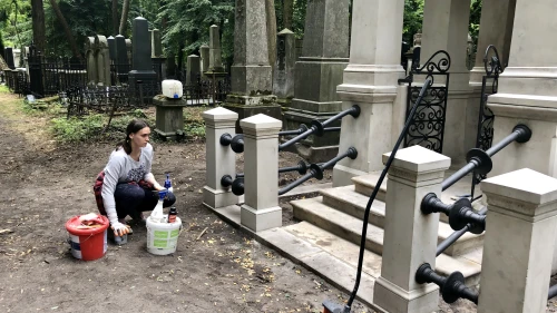 A woman cleans a tomb at Warsaw’s Jewish cemetery, July 2019. Photo by Eliana Rudee.