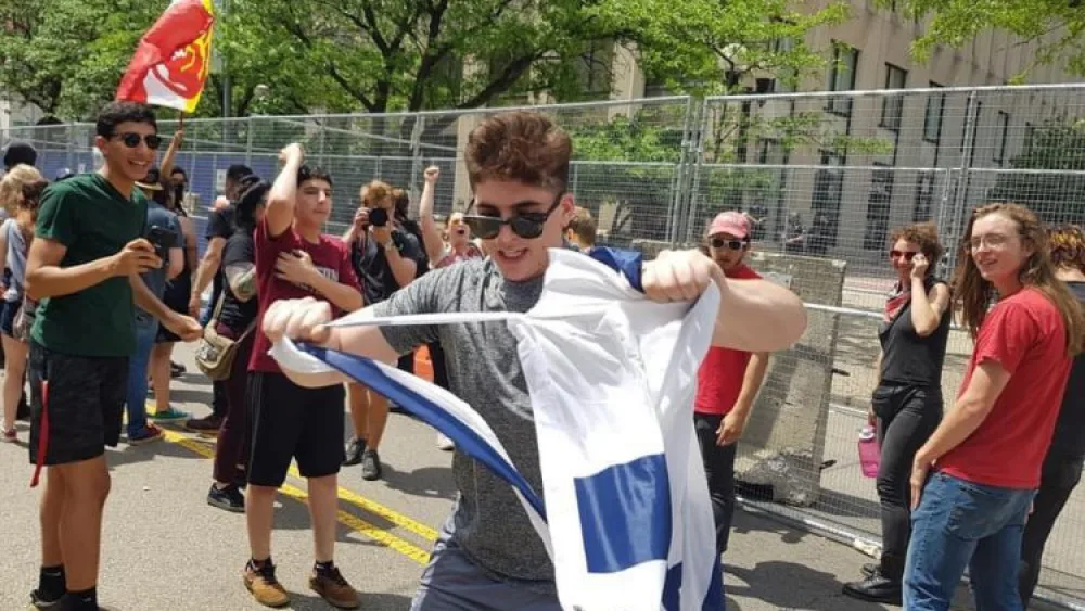 A counter-protester tears an Israeli flag on Third Street in Dayton next to Courthouse Square, the site of the Ku Klux Klan-affiliated Honorable Sacred Knights of Indiana's rally, May 25, 2019. Photo by Corine Fairbanks.