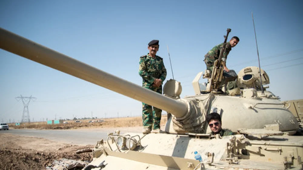 Members of the Kurdish Peshmerga forces on a tank outside Kirkuk, Iraq, in June 2014. Credit: Boris Niehaus via Wikimedia Commons.