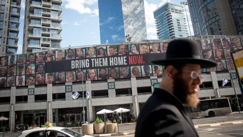 People walk by photographs of civilians who have been held or are still held hostage by Hamas terrorists in Gaza, in Ramat Gan. Jan. 21, 2024. Photo by Miriam Alster/Flash90.