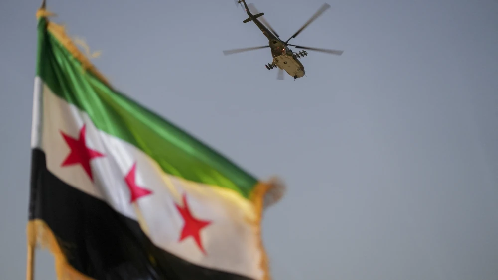 A military helicopter flies above a Syrian flag during the Syria Summer Family Festival in Damascus, Syria, on Aug. 9, 2026. Photo by Omar Albam / Middle East Images / AFP via Getty Images.