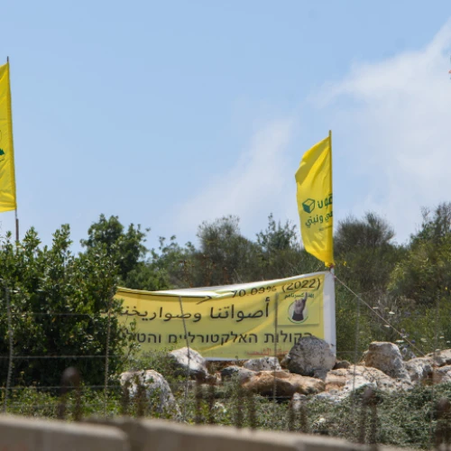 Hezbollah operatives in Lebanon raise the movement's banners at the Israeli border, July 3, 2022. Credit: Ayal Margolin/Flash90.