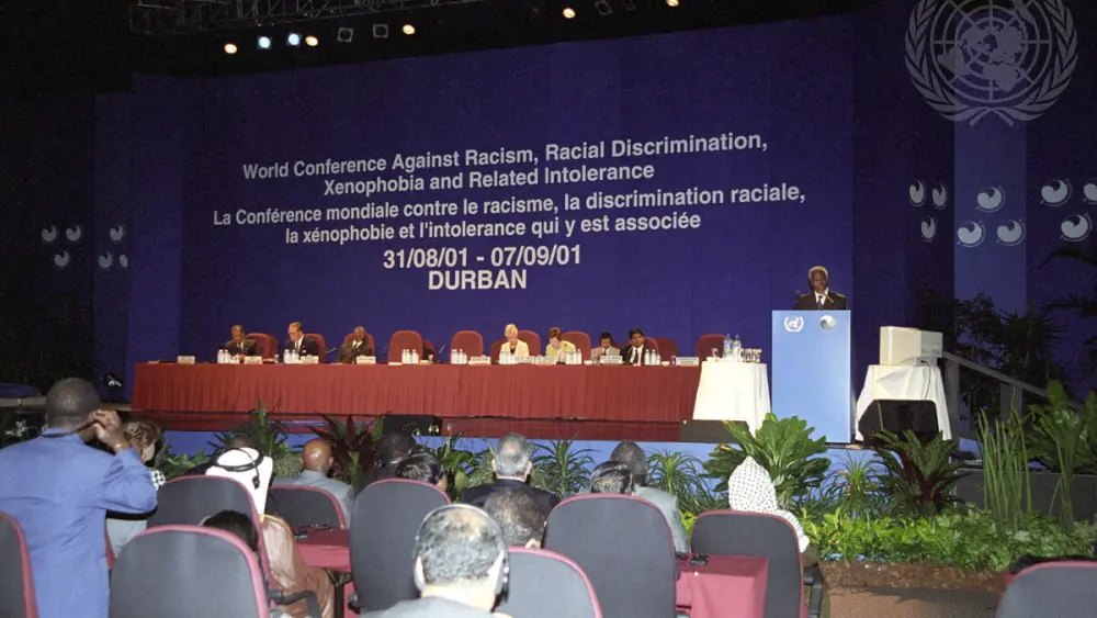 Secretary-General Kofi Annan (right, at podium) speaking at the opening of the World Conference Against Racism, Racial Discrimination, Xenophobia and Related Intolerance in Durban, September 2001. Credit: U.N. Photo/Evan Schneider.
