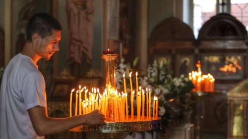 A man lights candles inside Jaffa's St. Peter's Russian Orthodox Church as Israel's Orthodox Christian communities celebrate Christmas, Jan. 7, 2024. Photo by Eitan Elhadez-Barak/TPS.